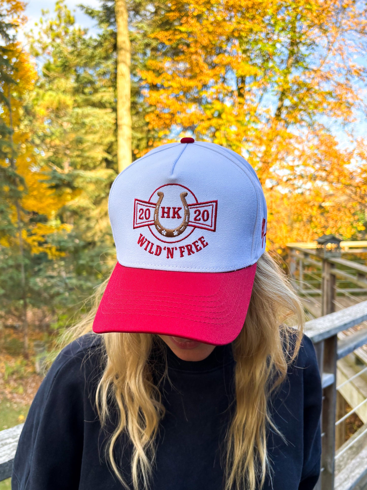 Front view of Hides & Kinds Wild N Free Hat in red and white with embroidered horseshoe logo and Wild N Free text.