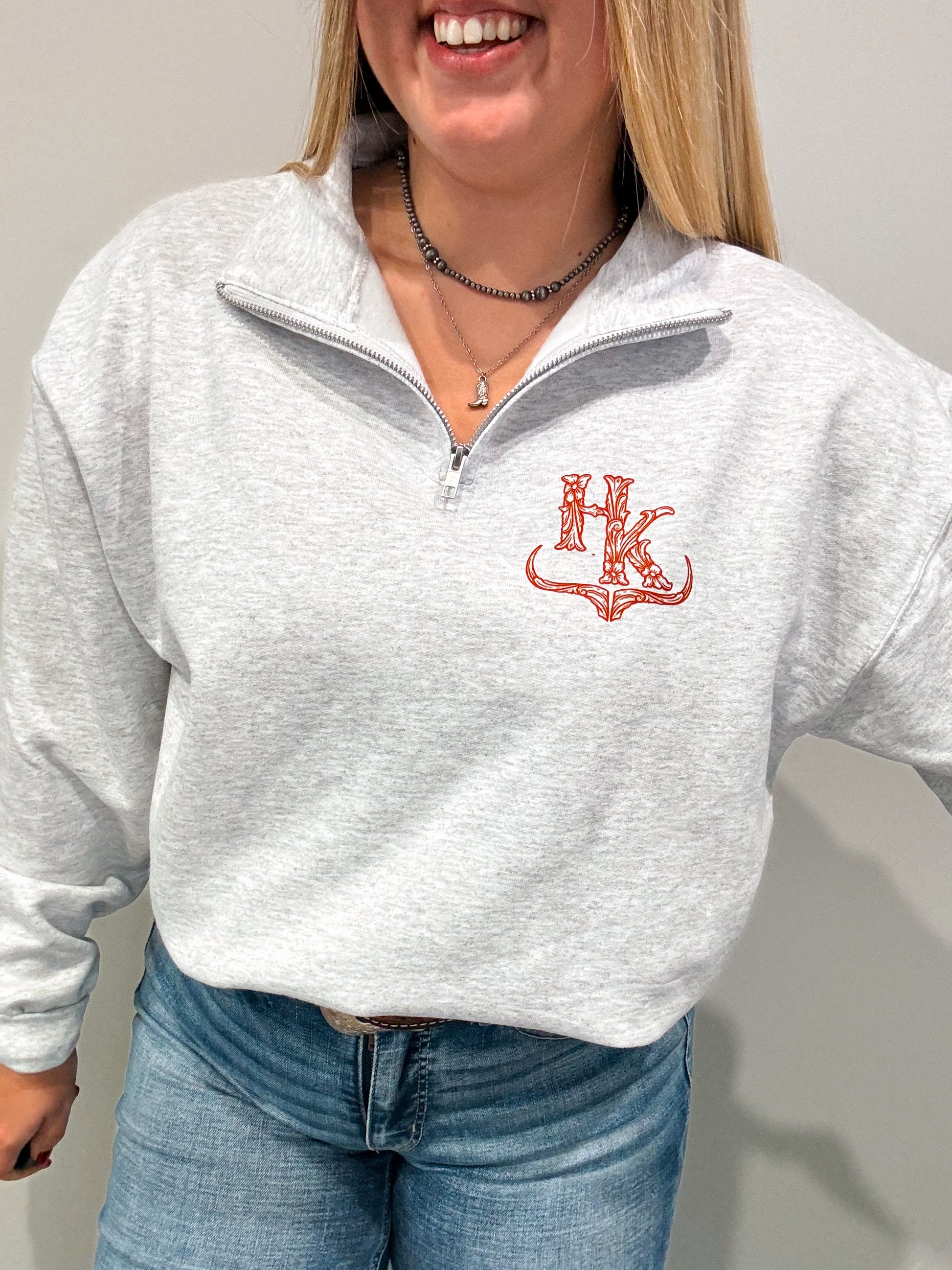 Close-up of the HK Quarter Zip with red branding, shown in a relaxed fit with the zipper partially open for a casual look.