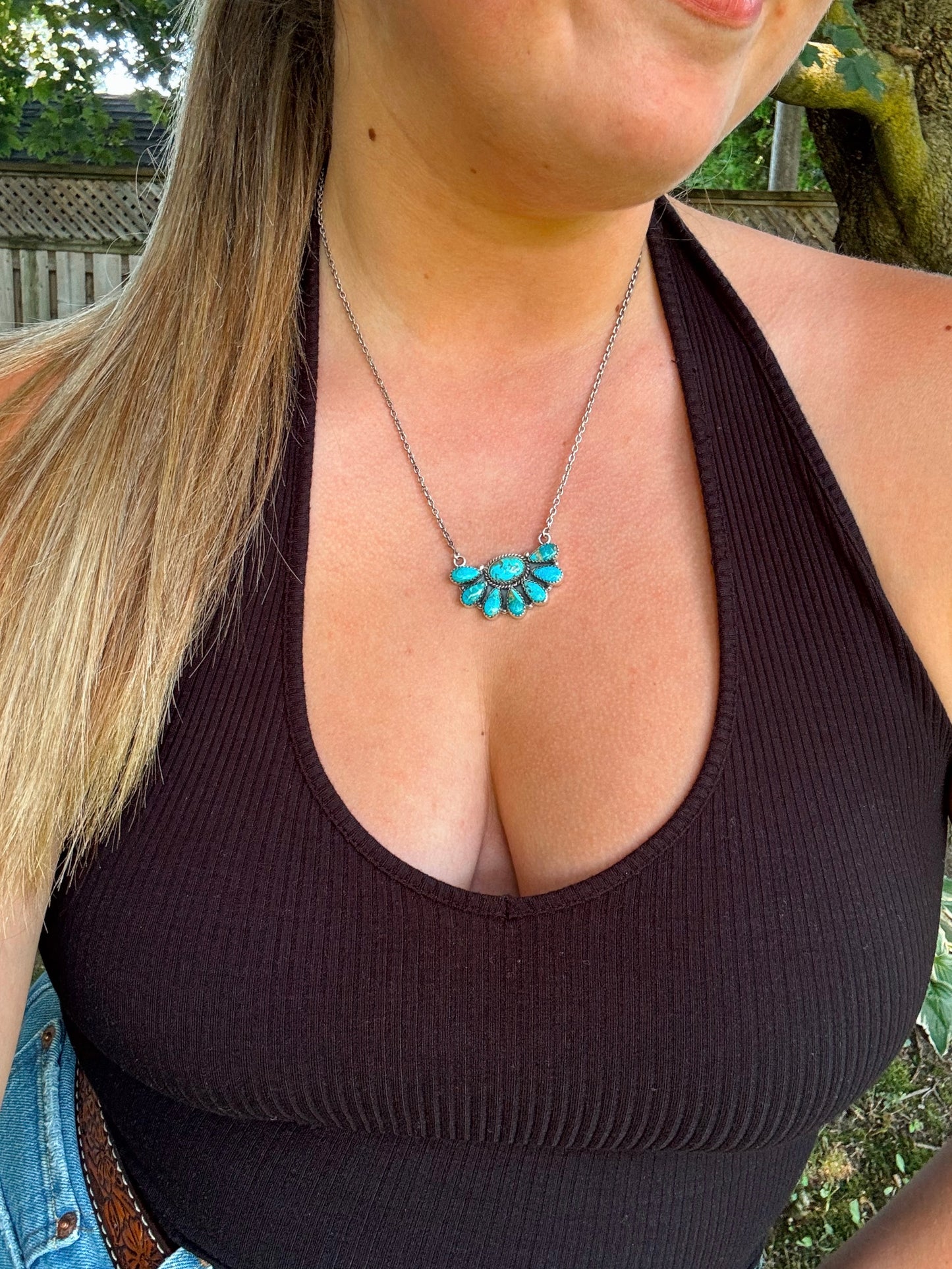 Styled image of the Bluebell Cluster Necklace worn with a black tank top, showcasing its dainty and feminine western design.