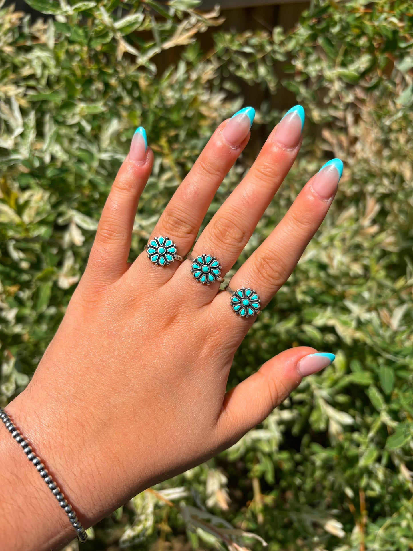 Stacked turquoise flower rings on hand – western boho jewelry by Hides & Kinds
