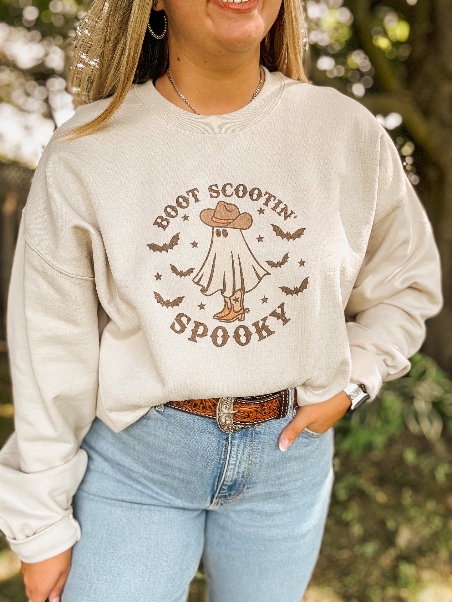 Close up of Boot Scootin' Spooky Halloween sweatshirt featuring western ghost graphic and fall vibes.