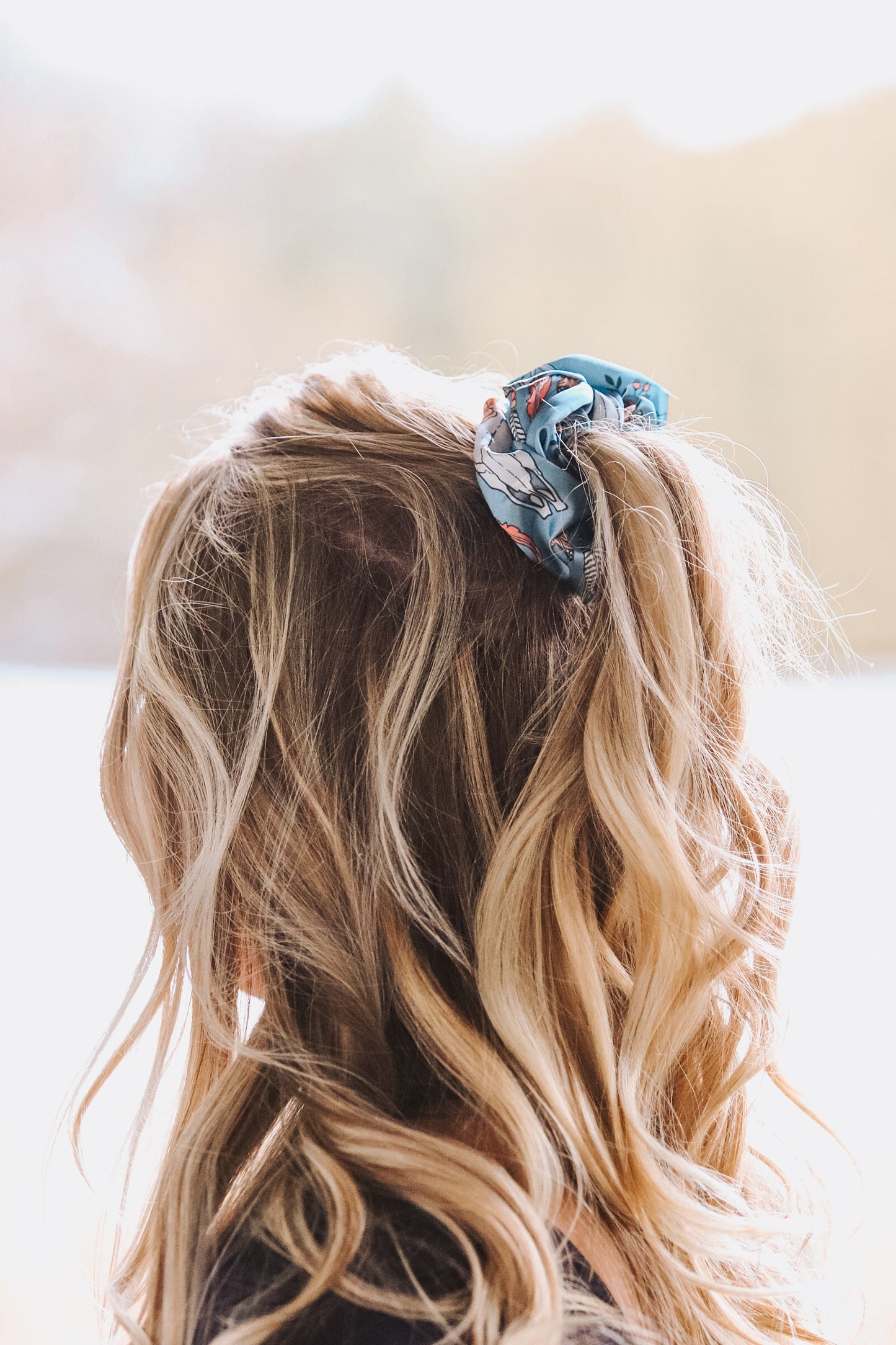 Close up of ponytail with blue Floral Longhorn Scrunchie featuring longhorn skull and floral print