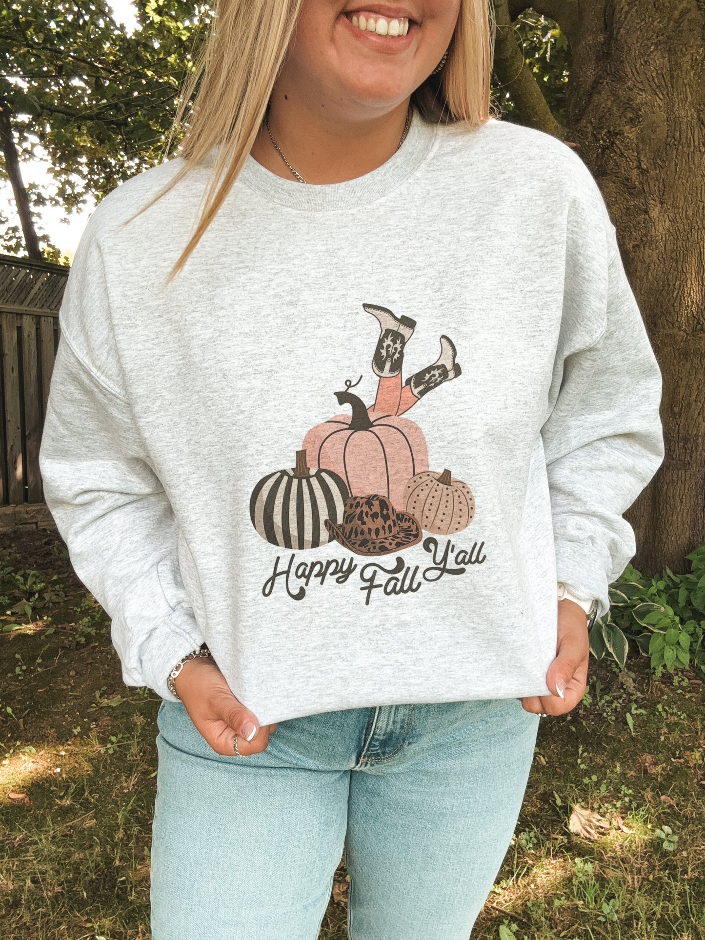 Detailed view of Happy Fall Y’all design featuring pumpkins, cowboy hat, and boots on light grey crewneck.