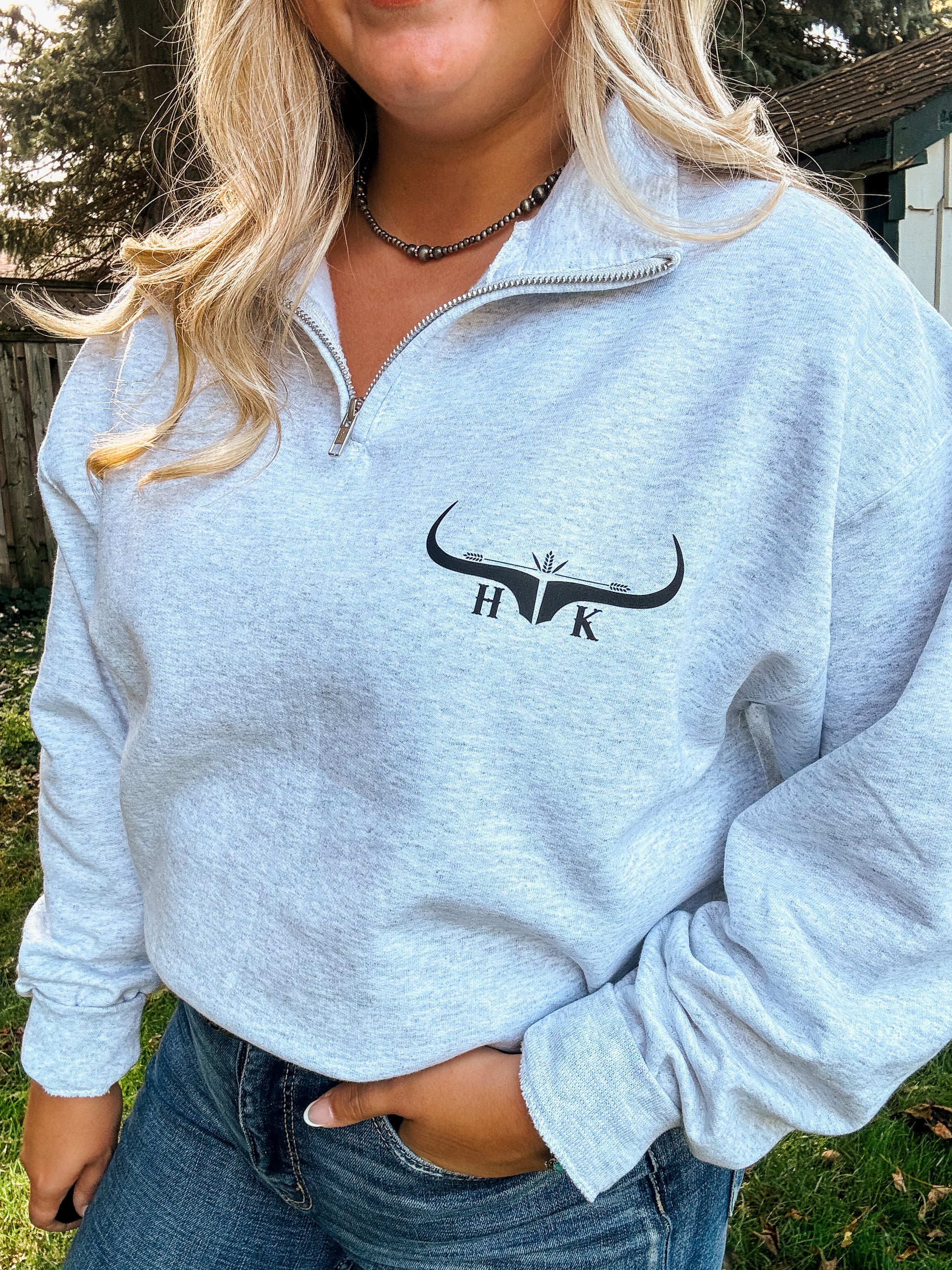 Western-inspired ash grey quarter zip sweatshirt modeled with denim jeans and belt