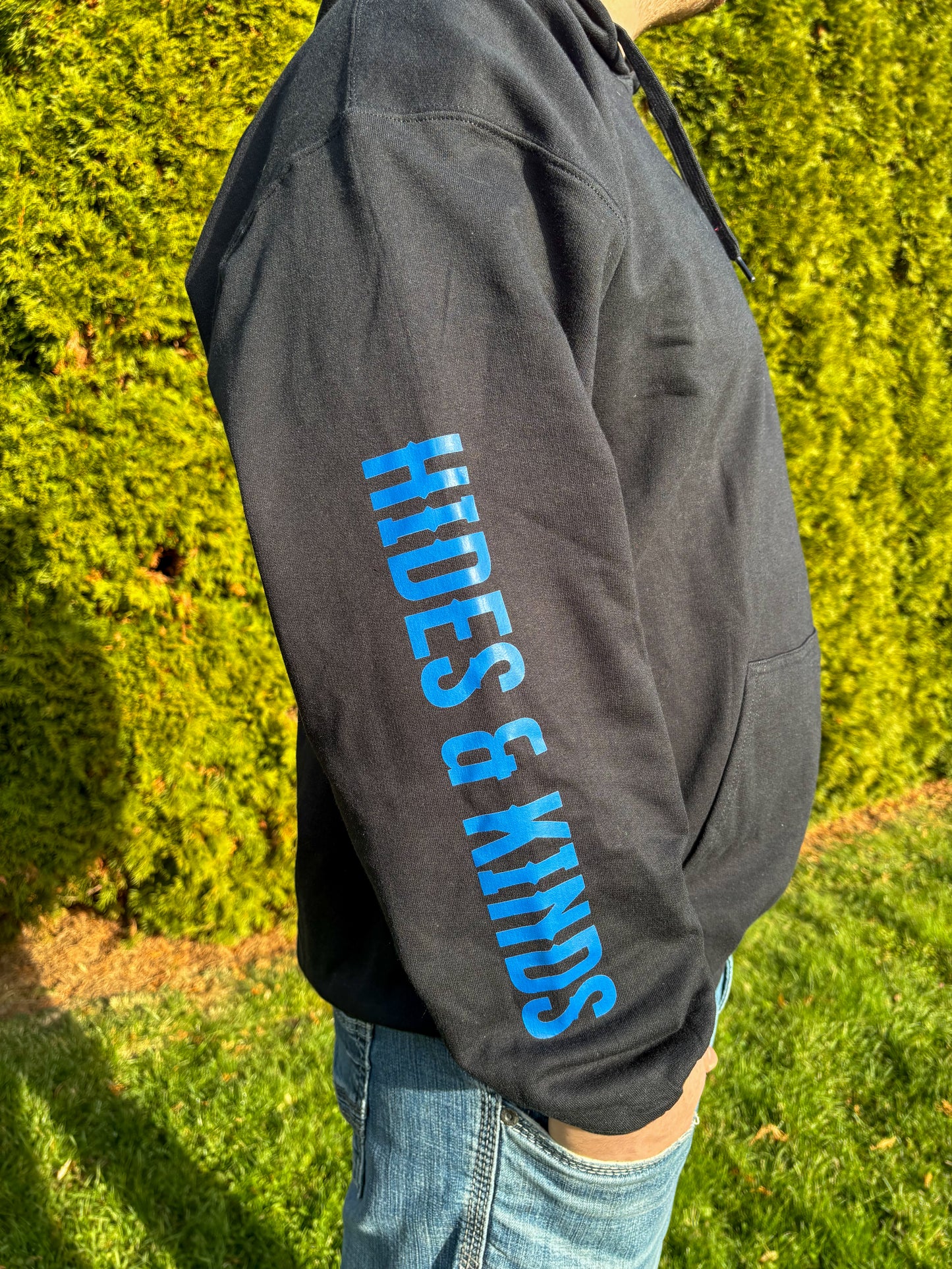 Close-up of sleeve print on black Midnight Longhorn hoodie reading Hides & Kinds