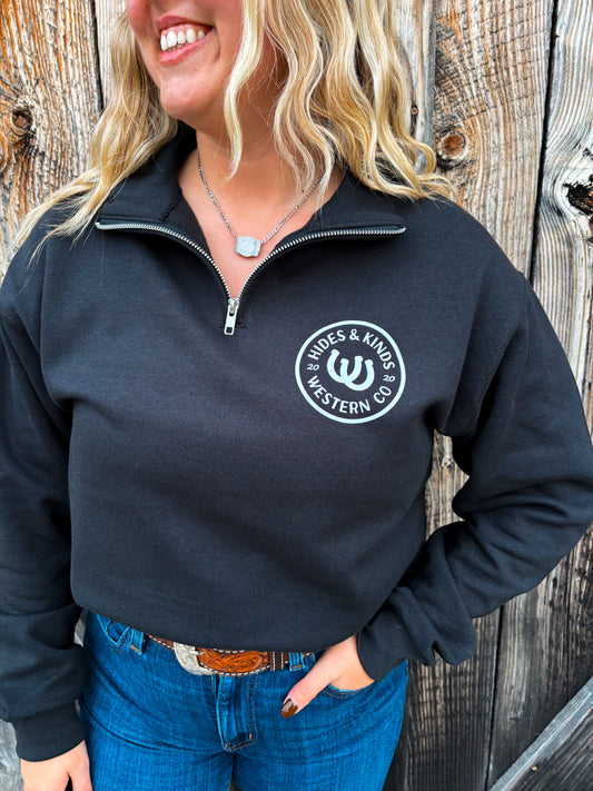 Front view of the Outrider Quarter Zip in black featuring the HK horseshoe Western Co. crest.