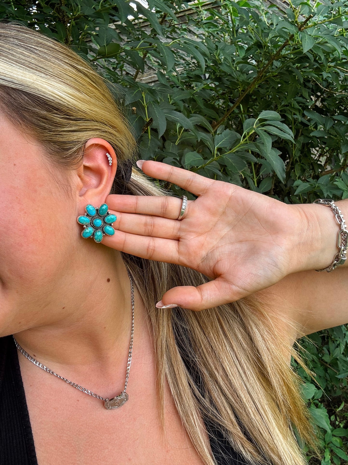 Model pulling her hair back to show H&K turquoise Rodeo Bloom earrings