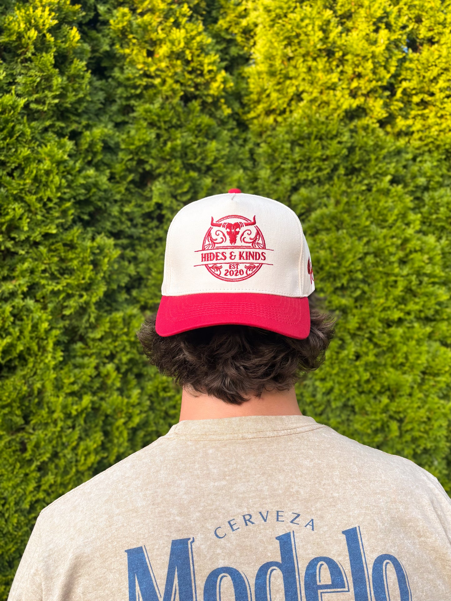 Man wearing The Stampede Snapback backwards, showing the bold embroidered Hides & Kinds logo on the back panel.