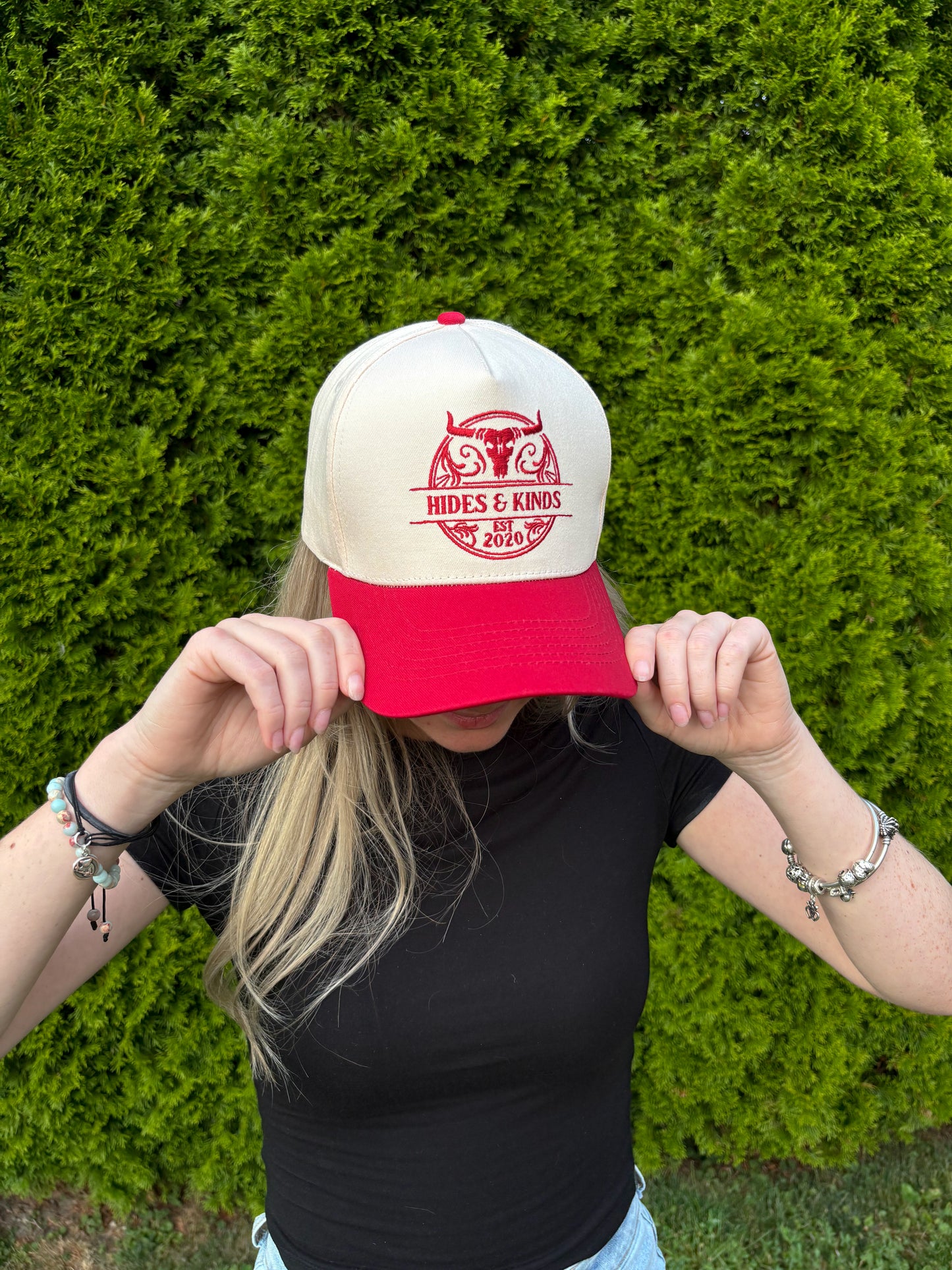 Close-up of woman adjusting The Stampede Snapback hat with both hands.