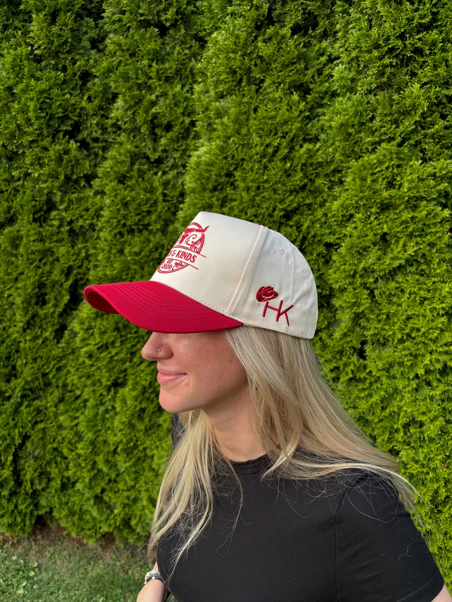 Side view of The Stampede Snapback hat on woman, showing HK embroidery on panel.