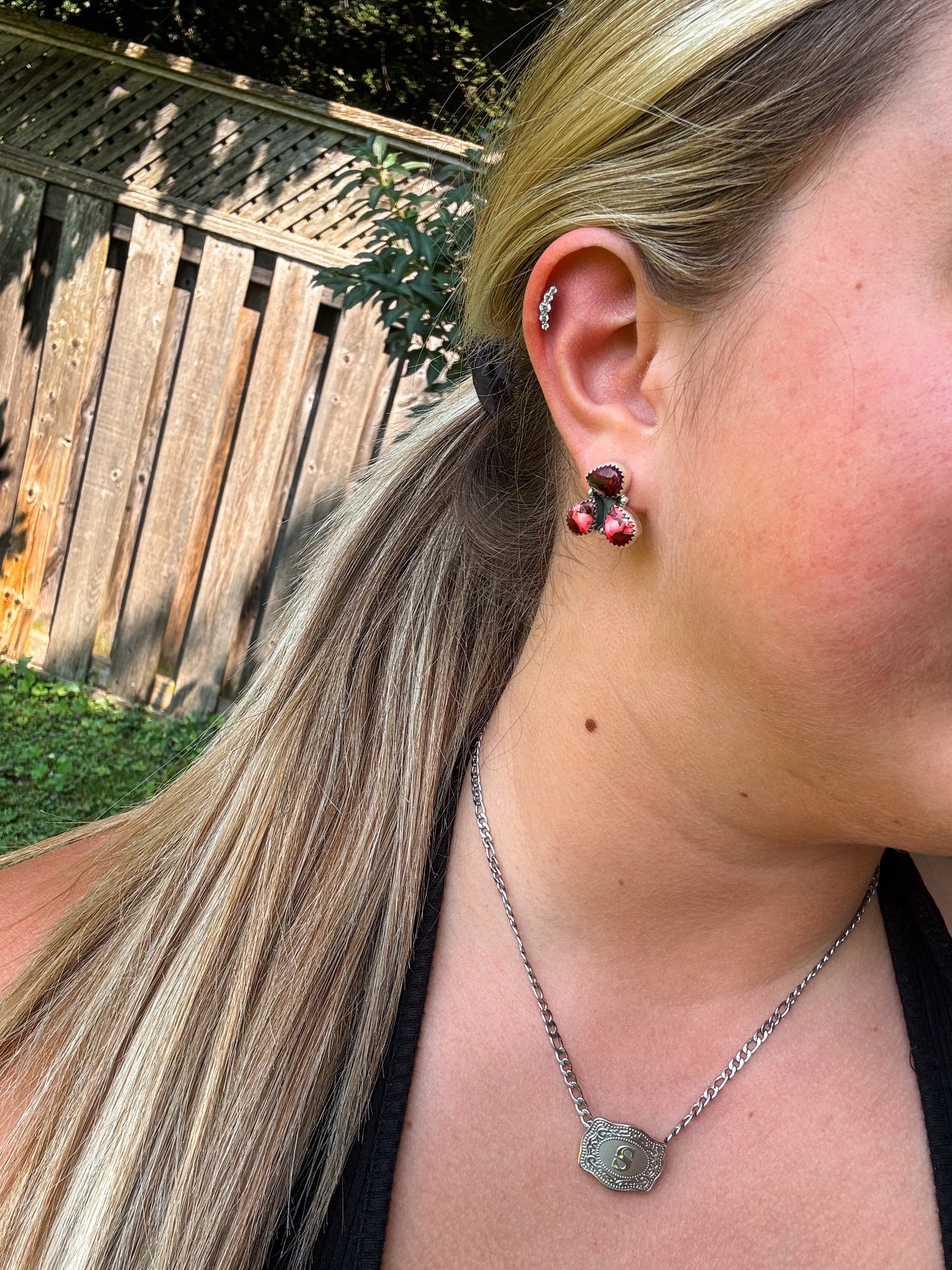 Close up of H&K Triple Stone Stud Earrings in Dahlia Rose pink stone worn with a black tank