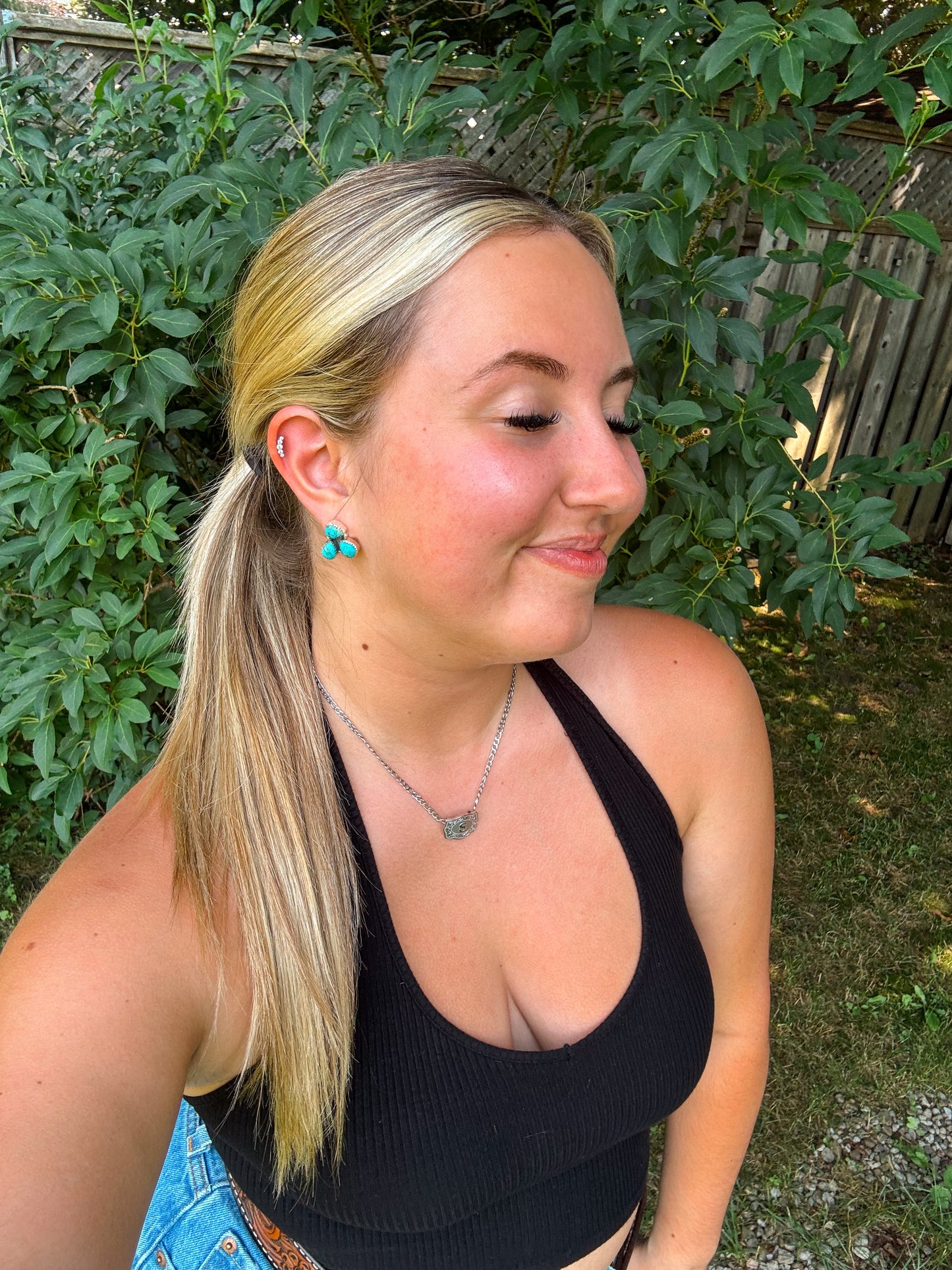 Turquoise Triple Stone Stud Earrings in natural light with greenery background and silver necklace