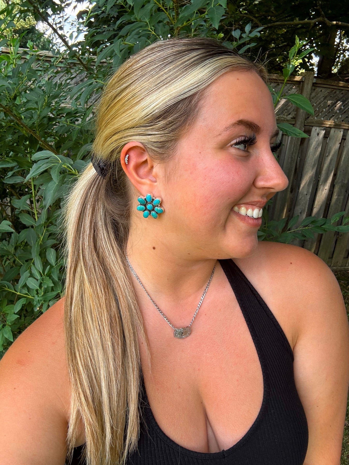 Side view of Rodeo Bloom Studs styled with a western chain necklace and black tank.