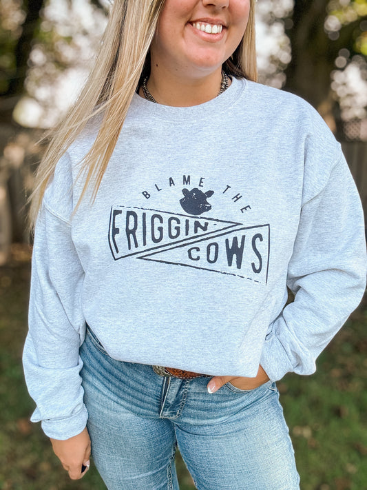 Side view of the Blame the Cows Crewneck showing western graphic and relaxed fit, styled with light wash denim.