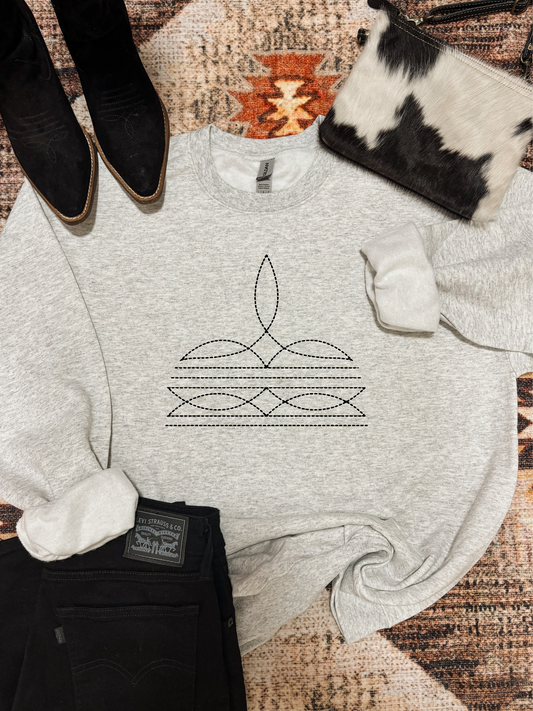 Ash grey crewneck with stitched boot design styled with black denim and cowgirl accessories