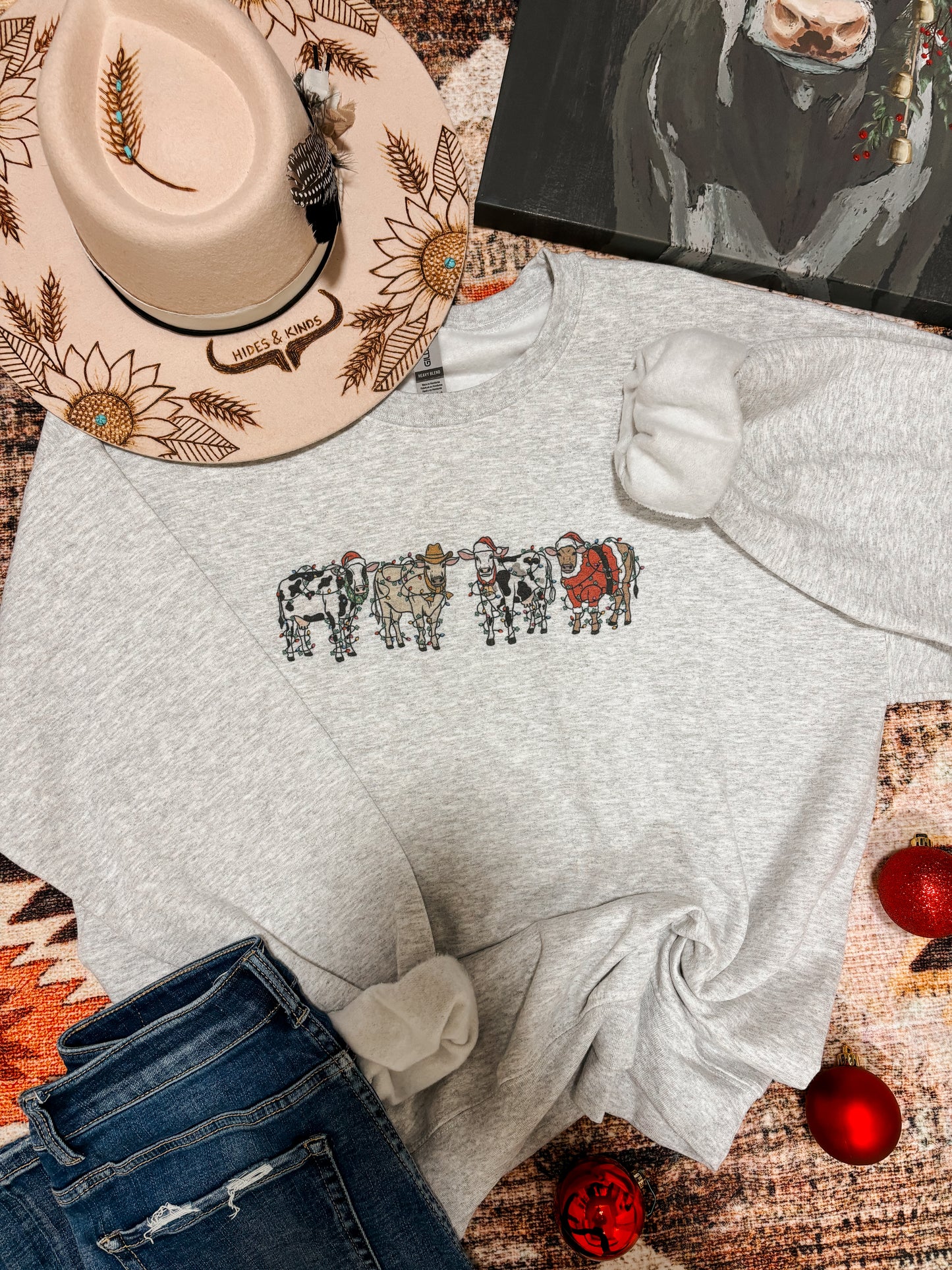 Close up of festive cow print on heather grey crewneck sweatshirt