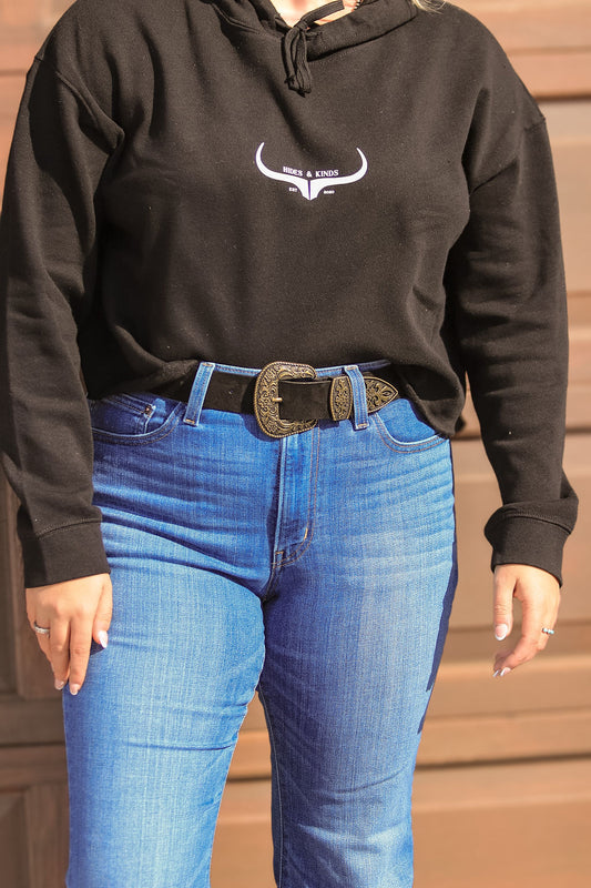 Side view of black suede belt with antique gold western buckle