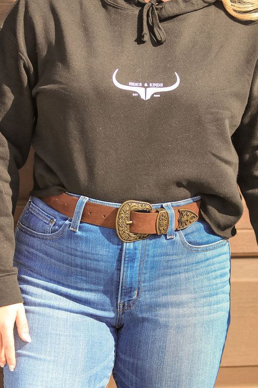 Close-up of antique gold engraved buckle on brown suede belt