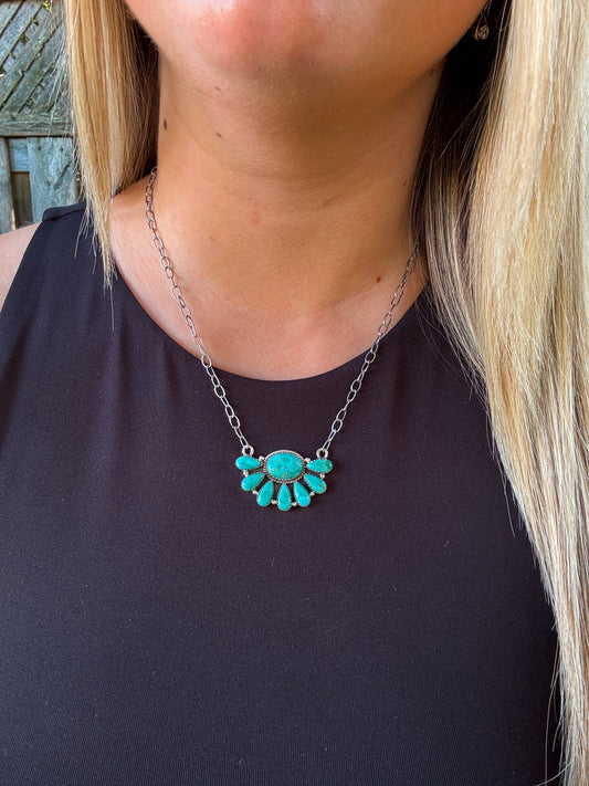 Close up of the Bluebell Cluster Necklace with round and teardrop turquoise stones arranged in a silver fan design.