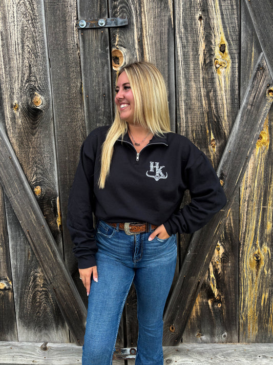 Full body image of a woman styling the black Hides & Kinds quarter zip with jeans and a belt