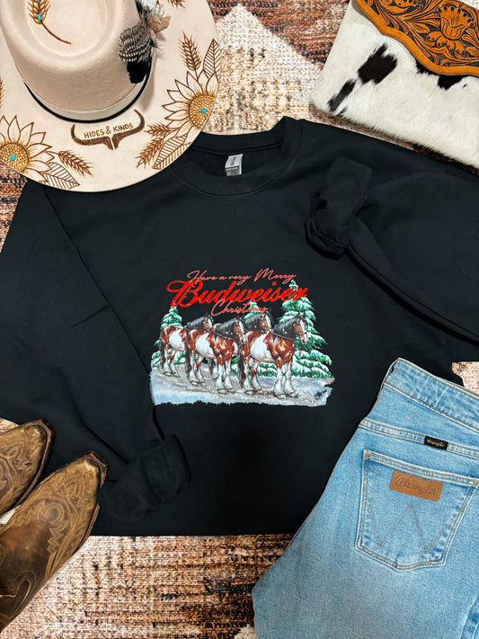 Western flat lay of black Budweiser Christmas crewneck styled with cowboy boots, denim, and Hides & Kinds sunflower hat.