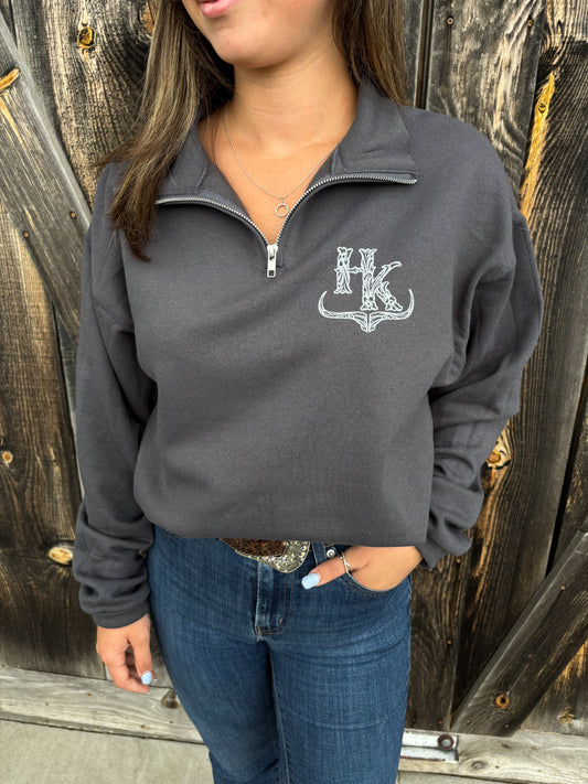 Model wearing Hides & Kinds charcoal grey quarter zip with tooled logo detail