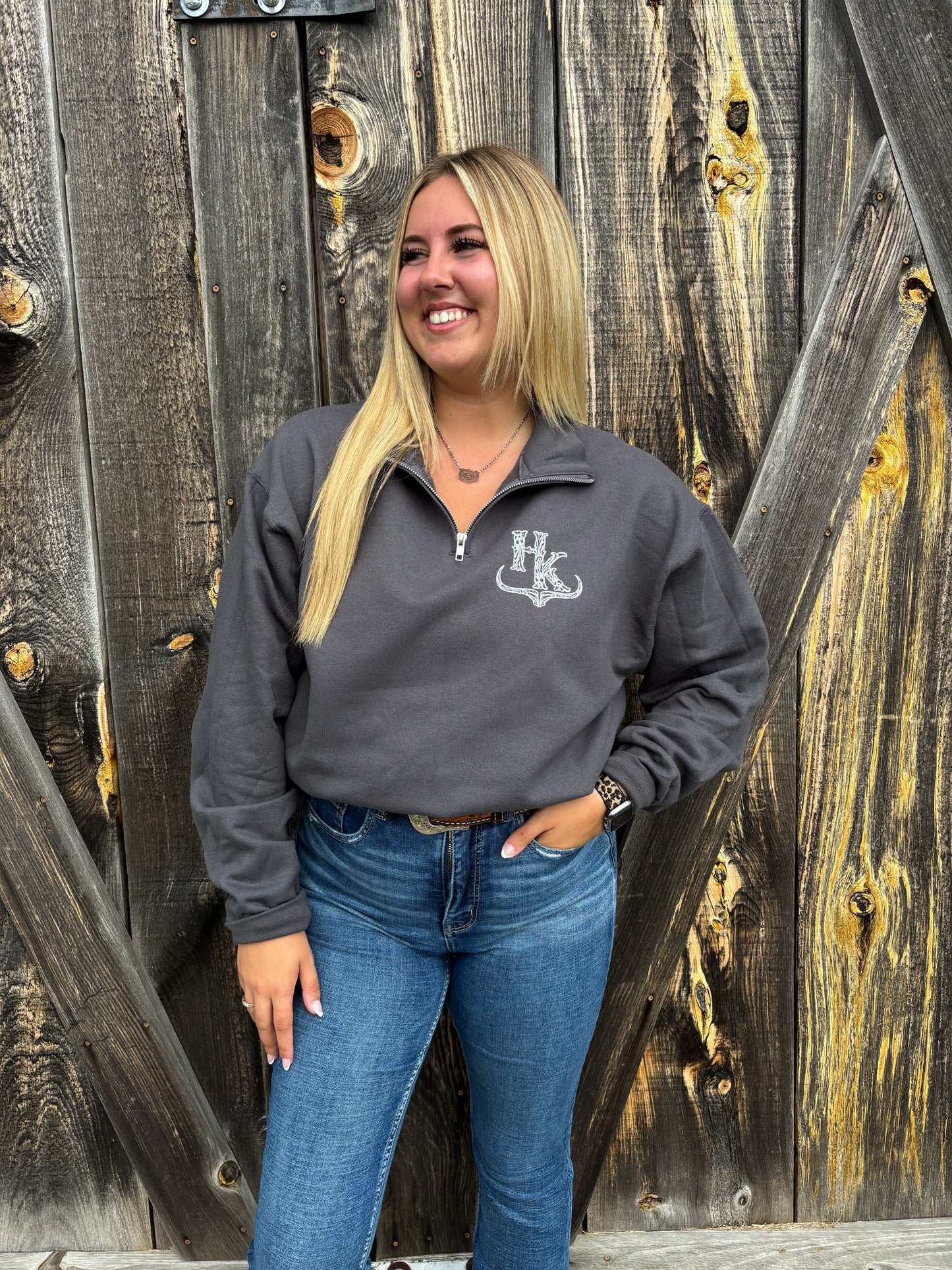 Country-inspired quarter zip in charcoal grey from Hides & Kinds worn with jeans and belt buckle