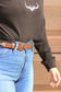 Close up of dual engraved silver buckles on western belt
