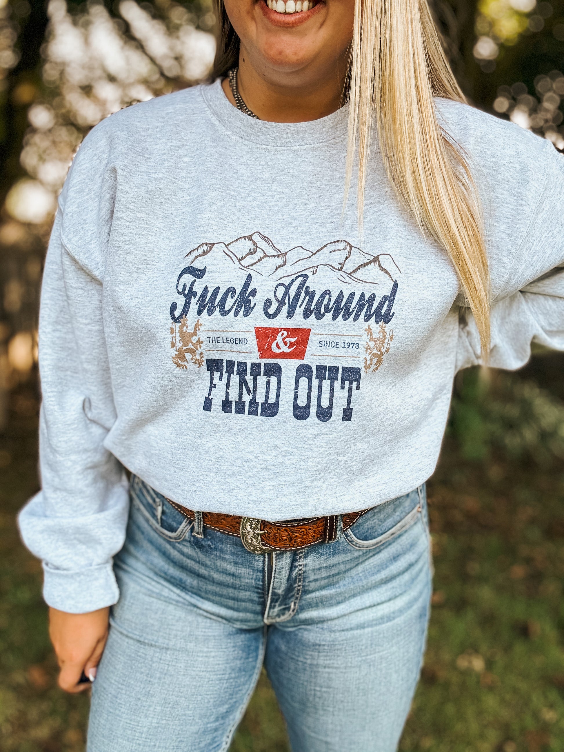 Close up of Hides & Kinds crewneck with bold western lettering and graphic print