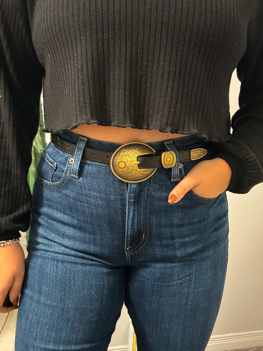 Black leather western belt with large gold concho buckle, front view