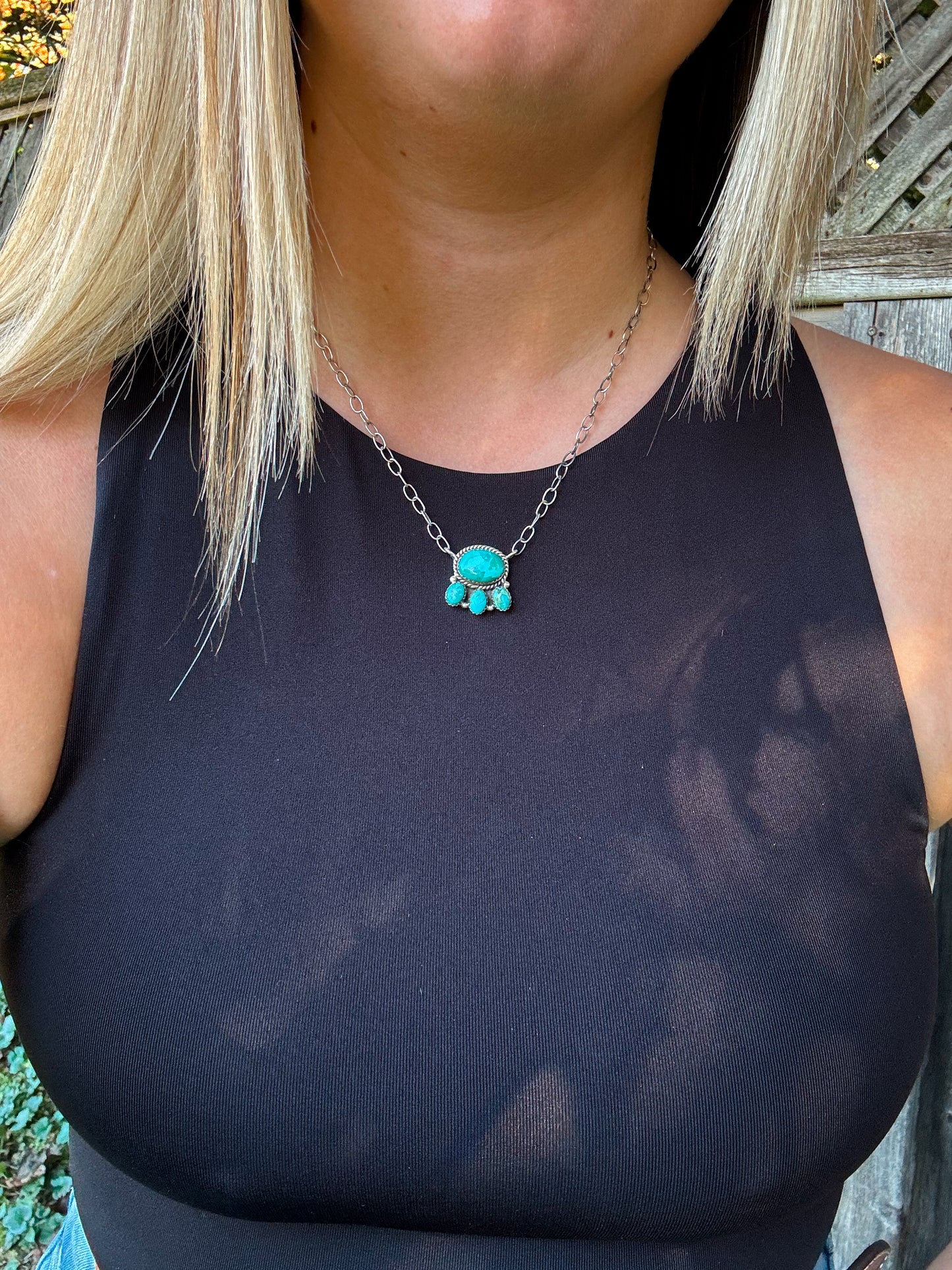 Model wearing Saddle Rock Necklace outdoors, showcasing turquoise pendant with triple drop detail