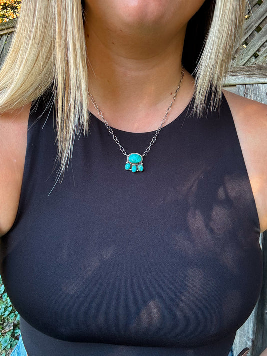 Model wearing Saddle Rock Necklace outdoors, showcasing turquoise pendant with triple drop detail