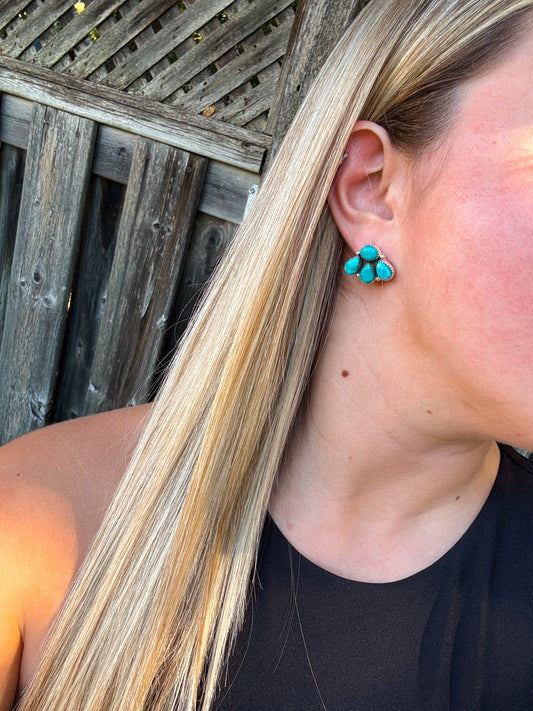 Side profile of turquoise stud earrings being worn with hair tucked behind ear