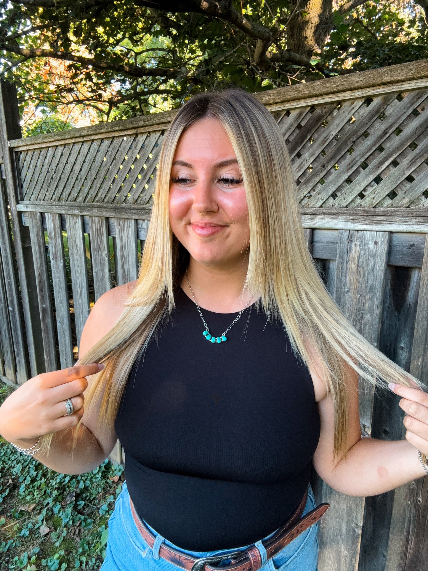 Woman wearing the Wild Sky Necklace with a black halter tank, styled with loose blonde hair and turquoise jewelry.