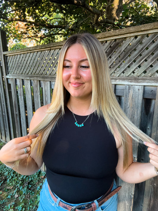 Woman wearing the Wild Sky Necklace with a black halter tank, styled with loose blonde hair and turquoise jewelry.