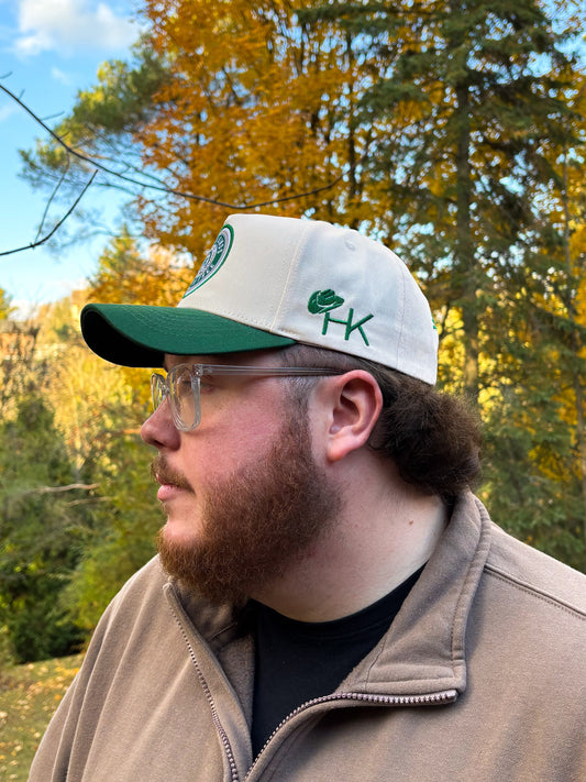 Side profile of Hides & Kinds Country Line Hat in green and cream featuring embroidered HK logo.