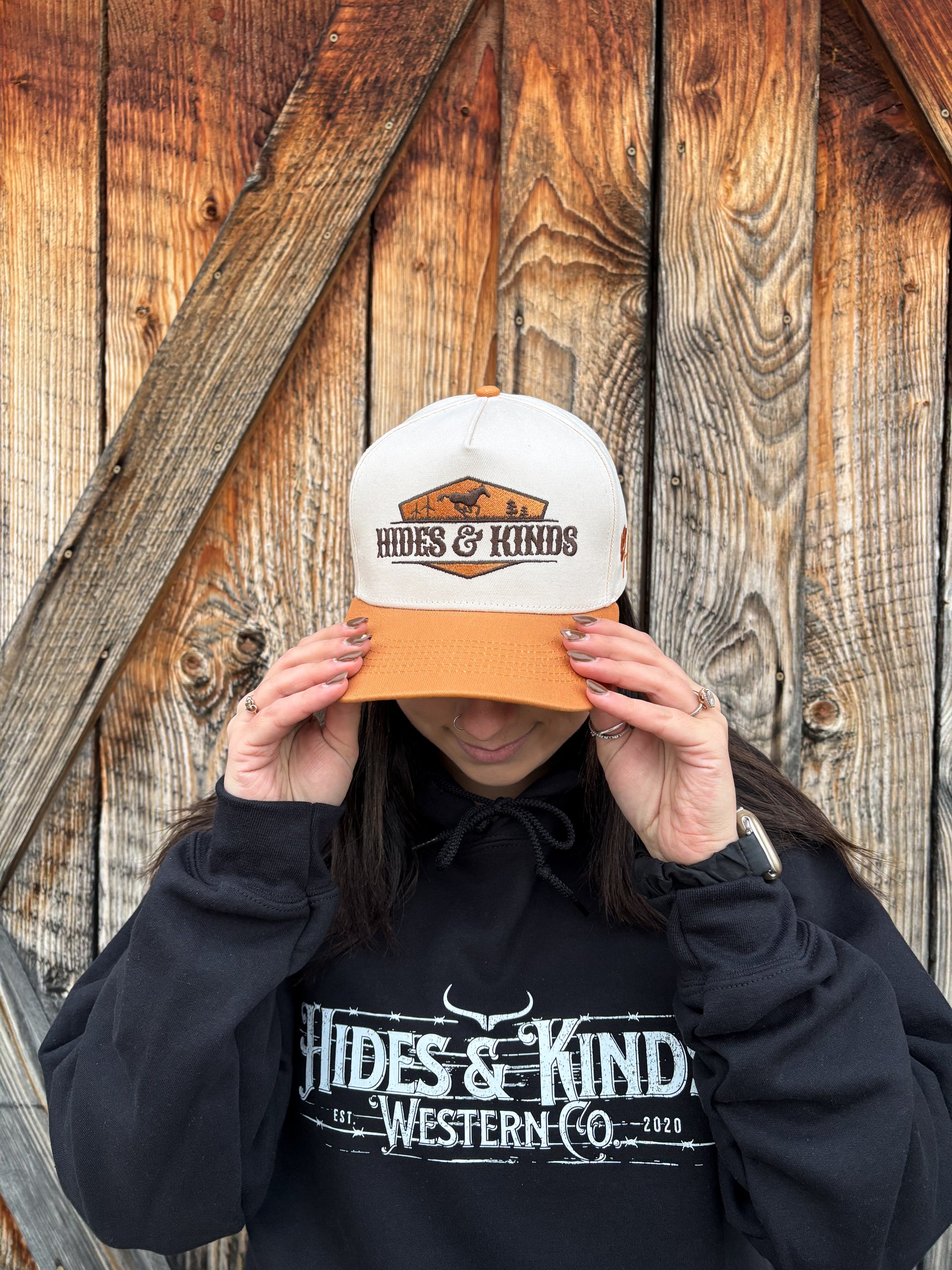 Angled front view of tan and cream Hides & Kinds Houston Hat highlighting embroidered desert logo patch.