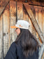 Side profile of Hides & Kinds Houston Hat in tan and cream featuring embroidered HK logo and Wild N Free lettering.