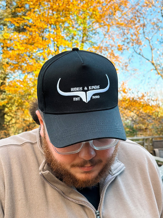 Front view of Hides & Kinds Original Logo Hat in black and white featuring embroidered longhorn logo and EST 2020 text.