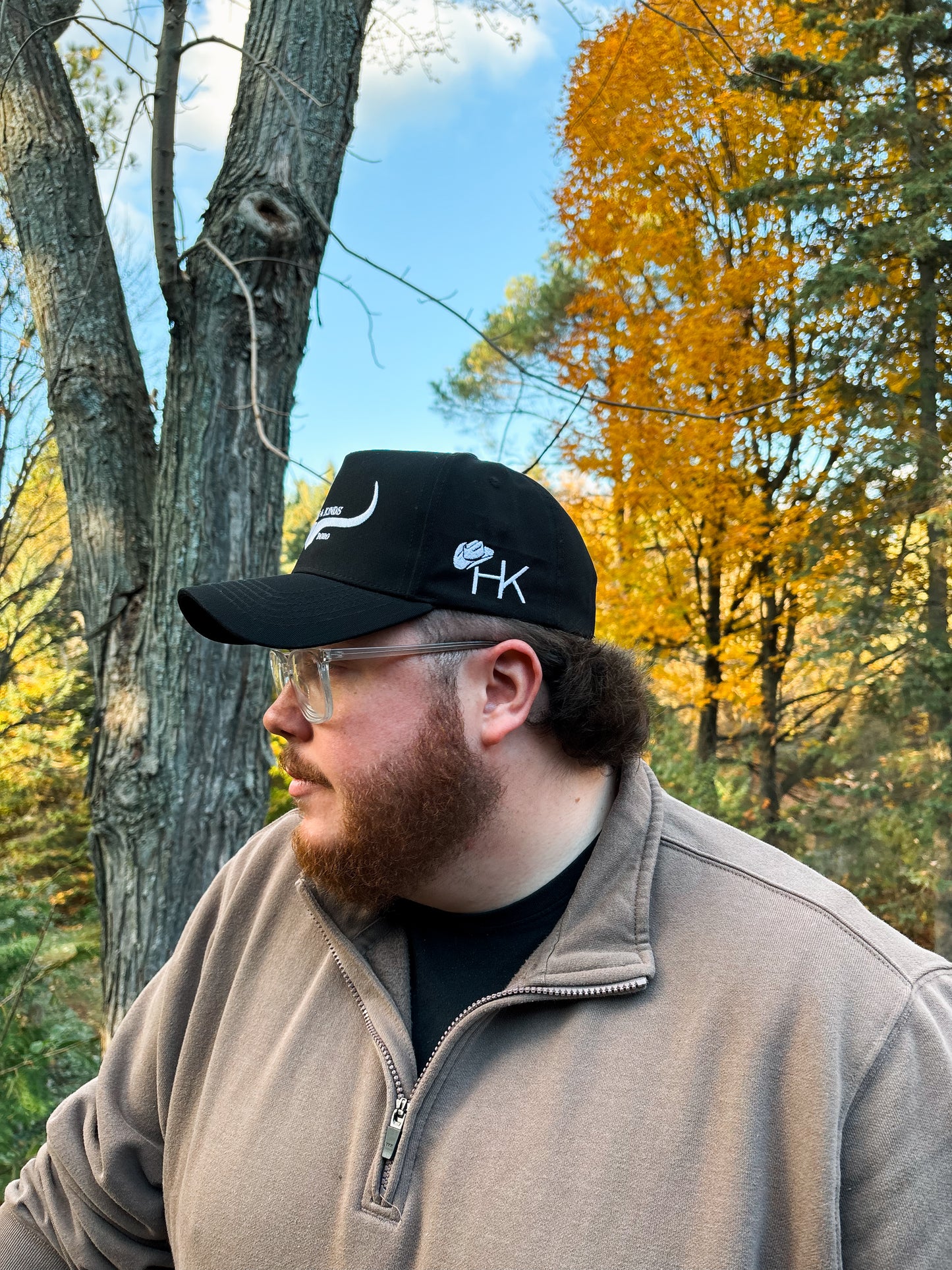 Side profile of black and white Hides & Kinds Original Logo Hat with embroidered HK logo on the side panel.