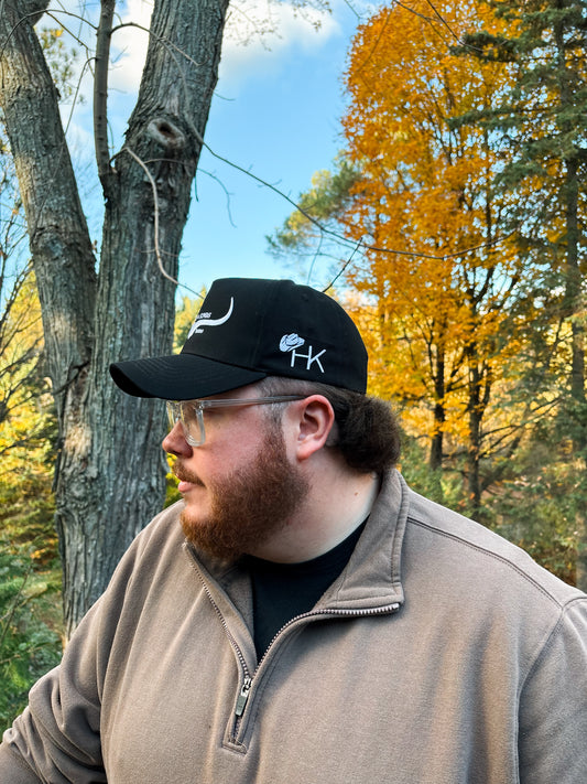 Side profile of black and white Hides & Kinds Original Logo Hat with embroidered HK logo on the side panel.