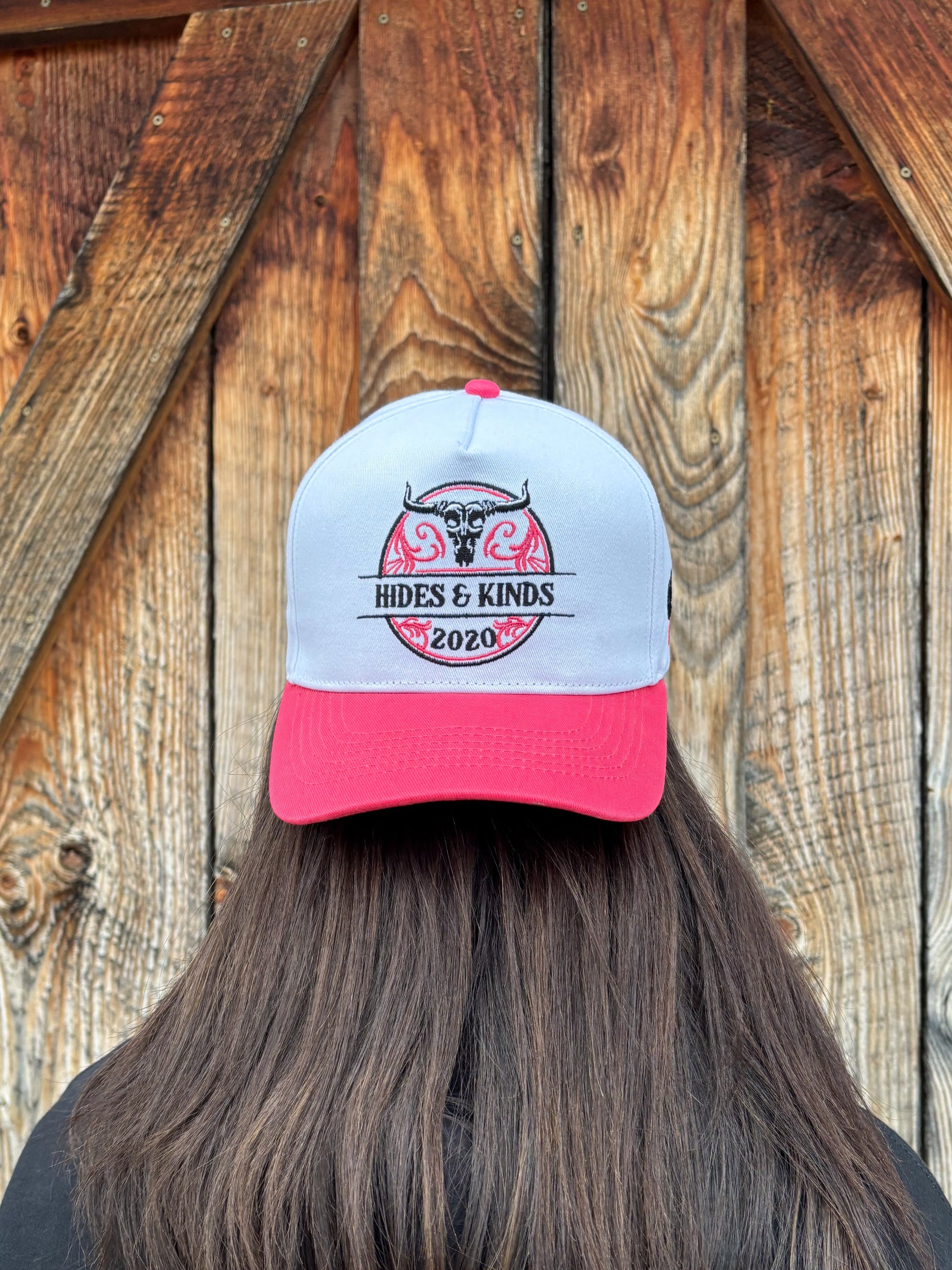 Front view of The Stampede Snapback by Hides & Kinds in pink and white with embroidered Wild N Free longhorn logo.
