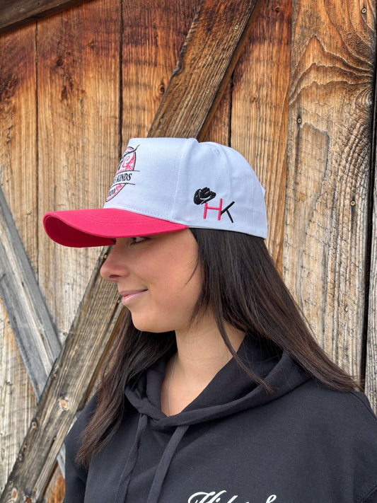 Side profile of Hides & Kinds Stampede Snapback in pink and white featuring HK embroidered hat logo.