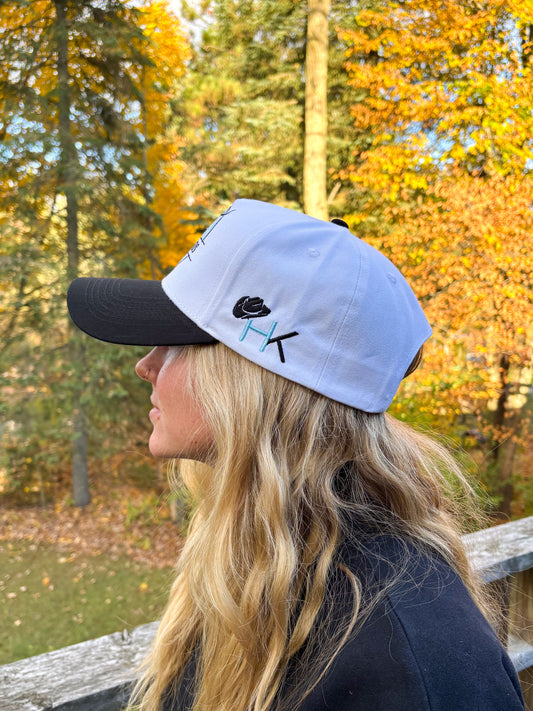 Angled front view of teal and black Hides & Kinds Stampede Snapback showcasing the western bull skull patch.