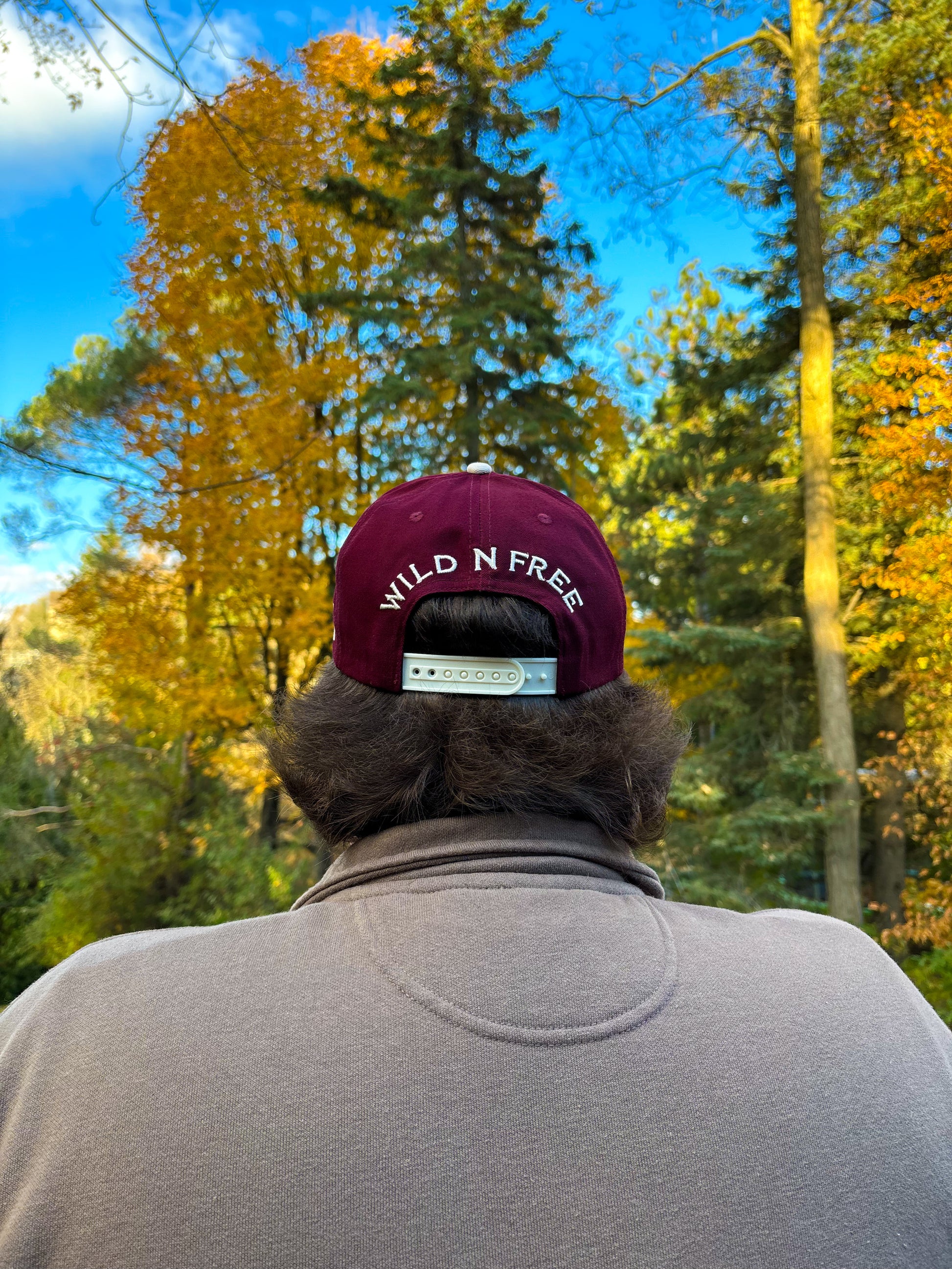 Back view of maroon and natural Hides & Kinds Wild N Free Hat featuring Wild N Free embroidery above the snapback.