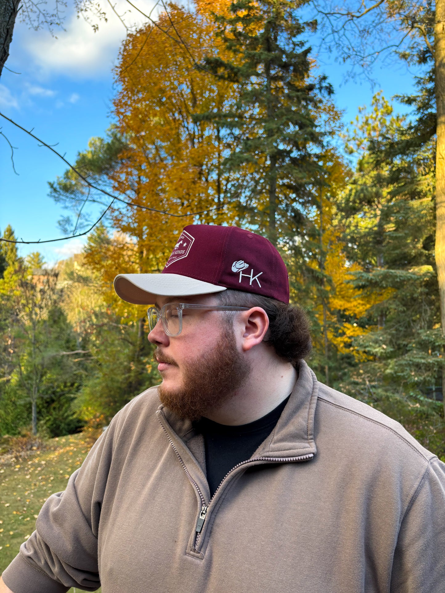 Side profile of maroon and natural Hides & Kinds Wild N Free Hat featuring embroidered HK logo.
