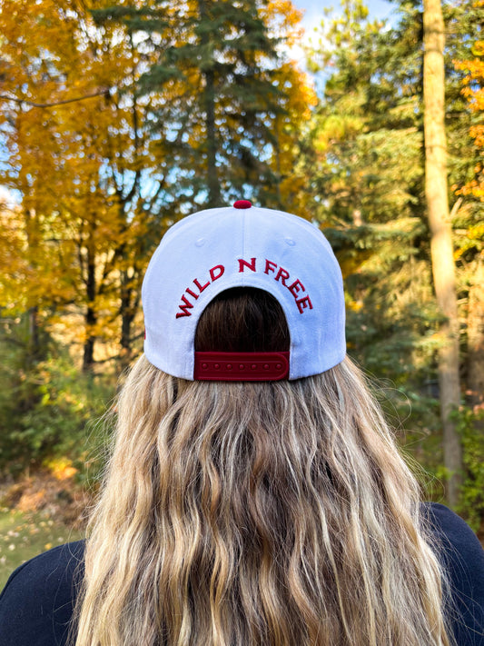 Back view of red and white Hides & Kinds Wild N Free Hat with embroidered Wild N Free lettering above the snapback closure.