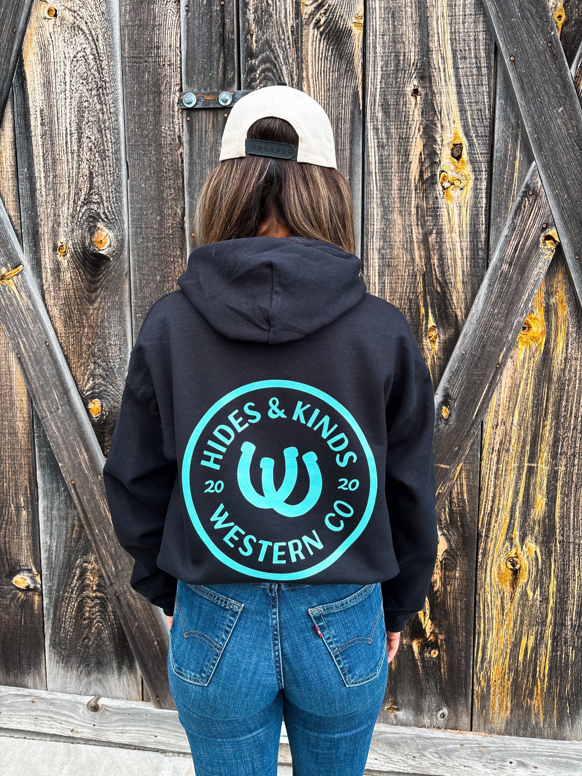 Back view of Outrider Hoodie in black with turquoise horseshoe logo – Hides & Kinds