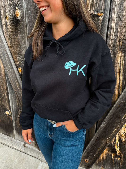 Front close-up of Outrider Hoodie featuring HK cowboy hat logo in turquoise