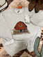 Close up of holiday barn and longhorn design on grey western crewneck
